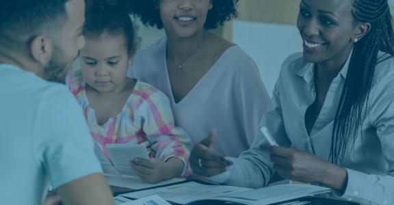 Group of adults smiling with small child reading