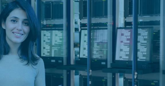 Woman smiling with back to computer screens of code