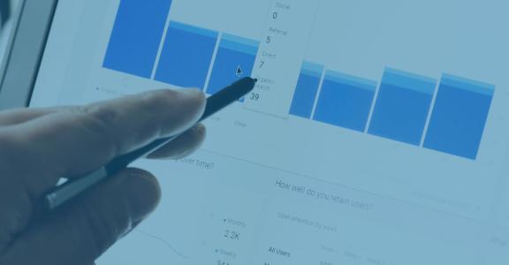 Hand with pen pointing at blue bar graph