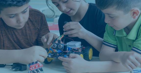 Three children building a robot car